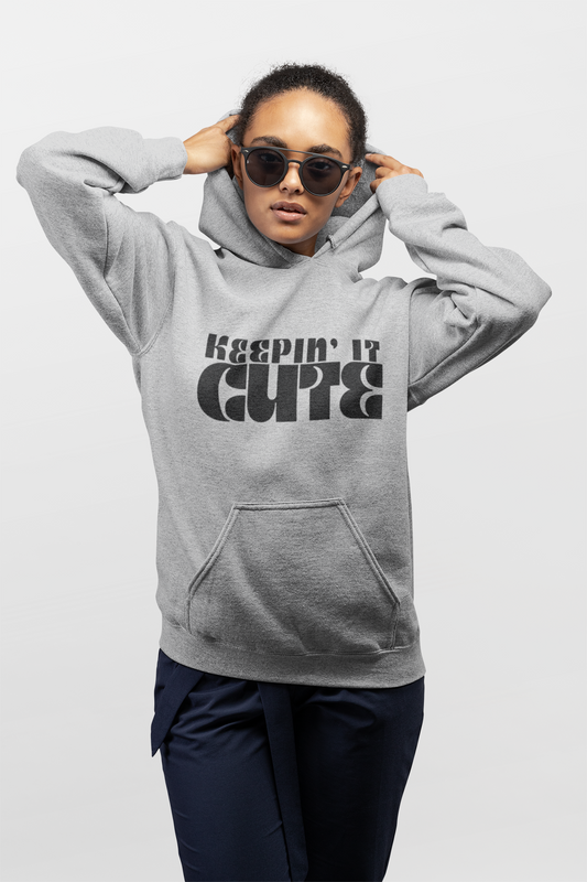Person wearing a gray hoodie with 'Keepin it Cute' text on a white background