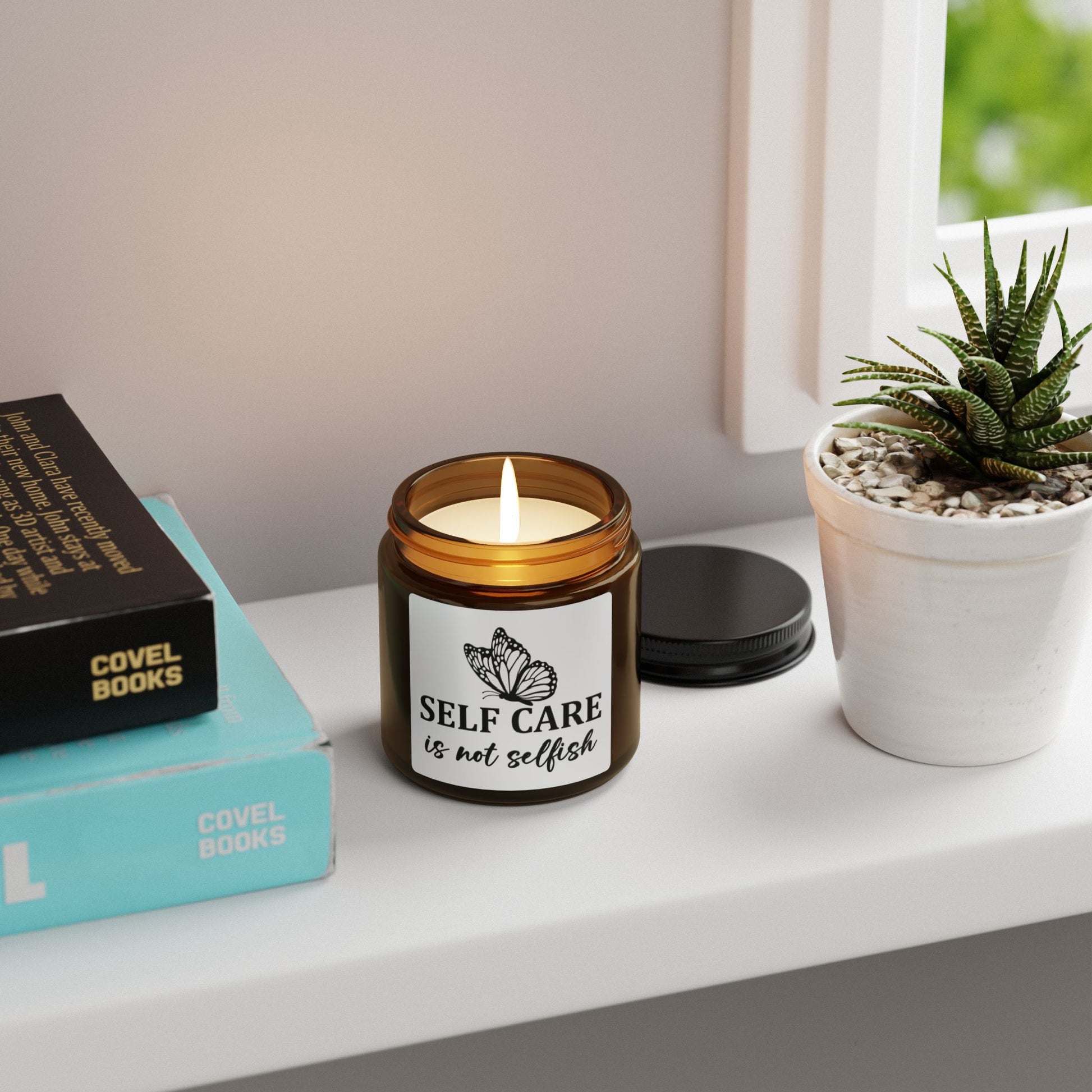 Candle with 'Self care is not selfish' label on a shelf with books and a plant