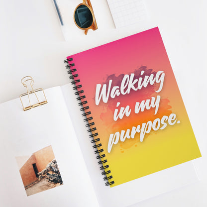 Notebook with 'Walking in my purpose' quote on a white surface