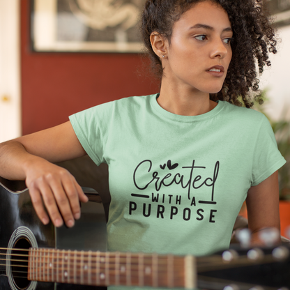 Woman wearing a light green t-shirt with 'Created with a Purpose' text, holding a guitar.