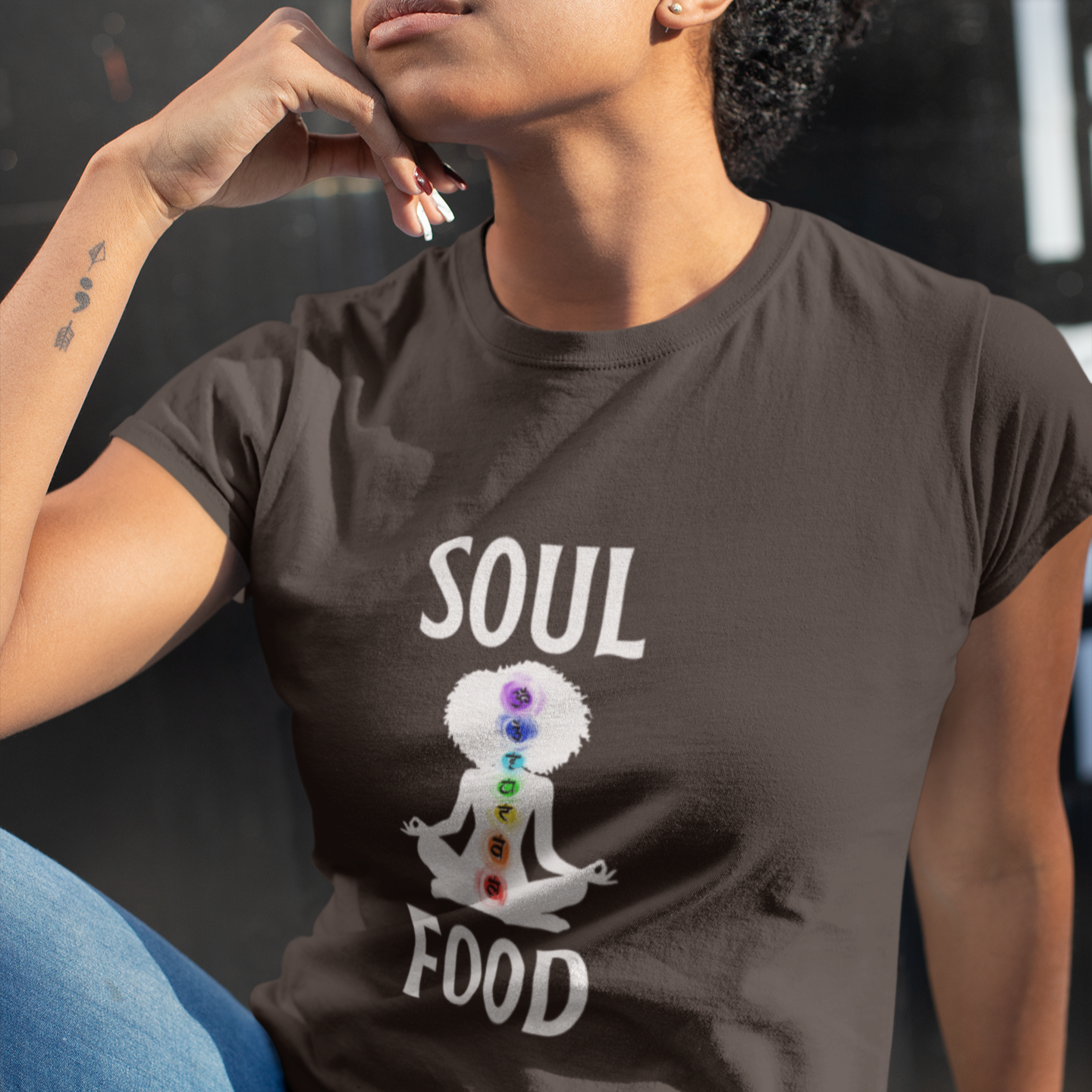 Person wearing a brown t-shirt with 'Soul Food' design featuring a person meditating with chakra colors.