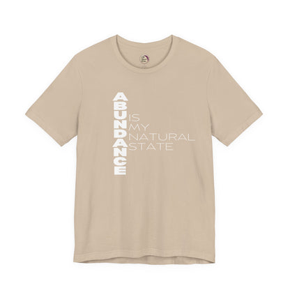 Beige t-shirt with 'ABUNDANCE IS MY NATURAL STATE' text on a white background