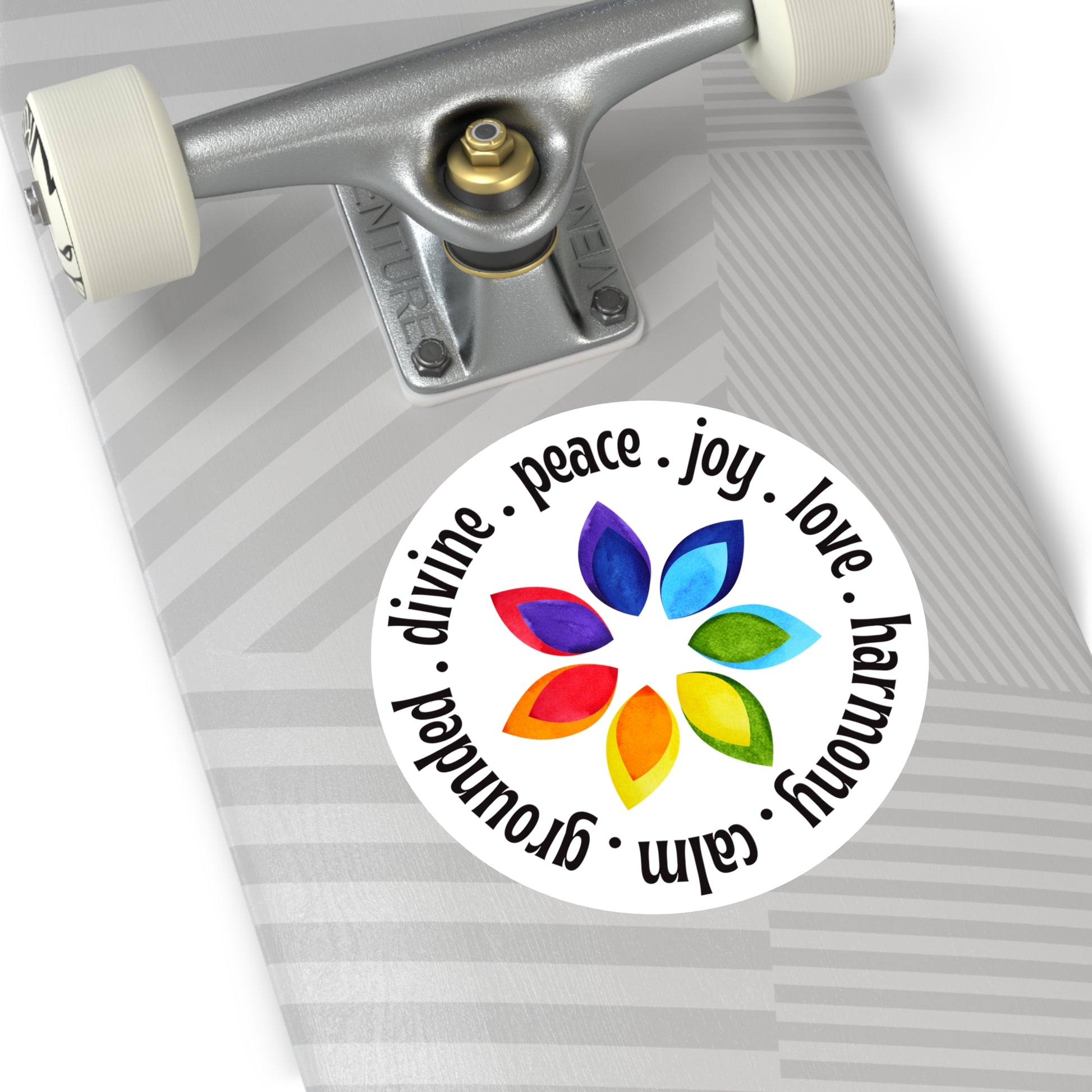 Skateboard with a colorful sticker featuring words and flower design on a white background