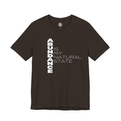 Brown t-shirt with white text 'ABUNDANCE IS MY NATURAL STATE' on a white background