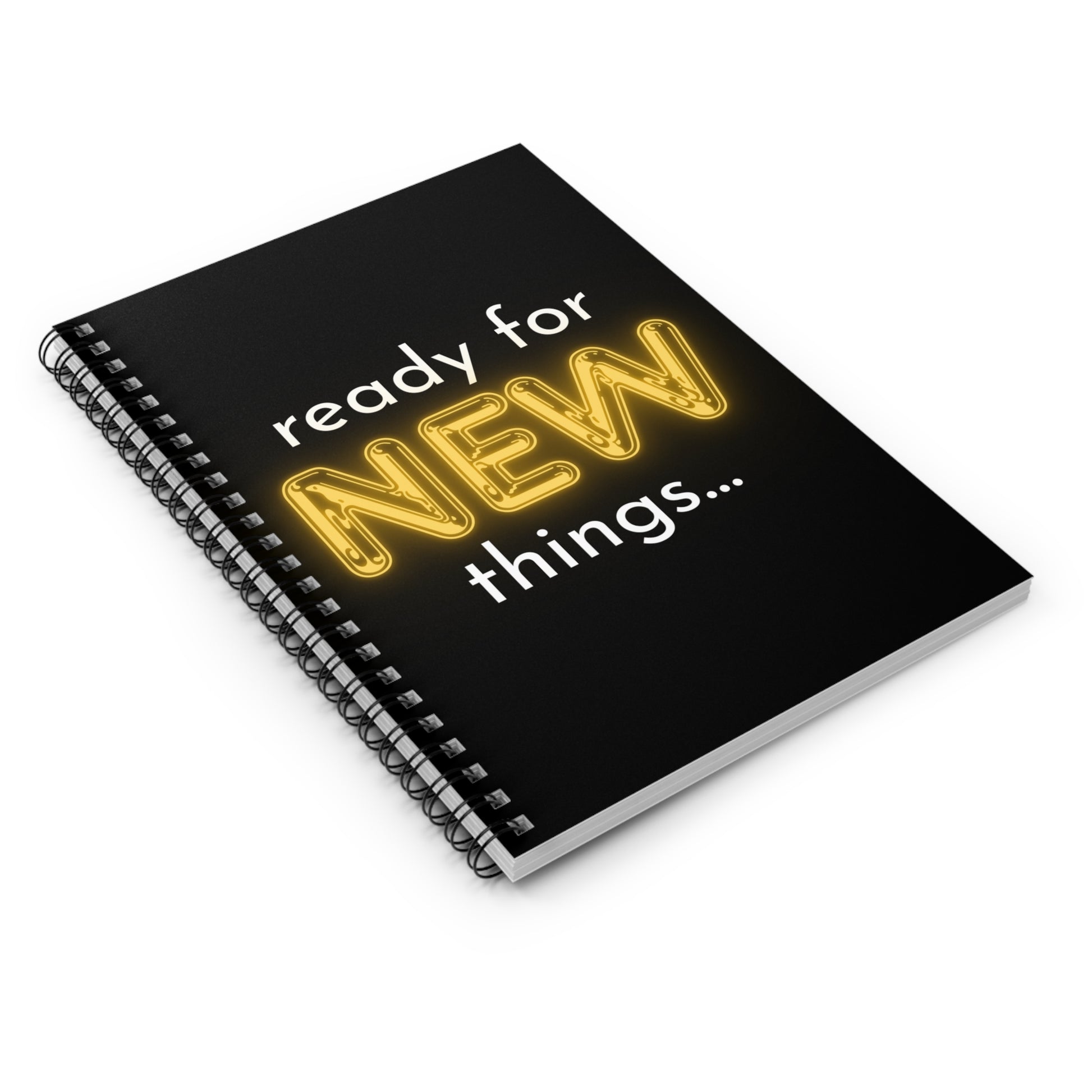 Black notebook with yellow text 'ready for NEW things...' on a white background